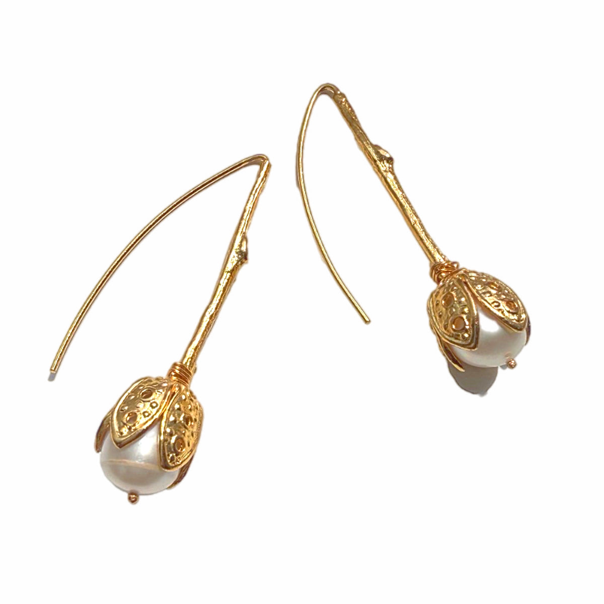 Handmade gold-plated Etruscan style tulip design pull through earrings with pearl drops Against white background 