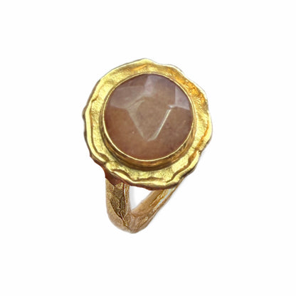 A handmade gold-plated cocktail gemstone ring with an orange quartz stone, shown on a plain white background.