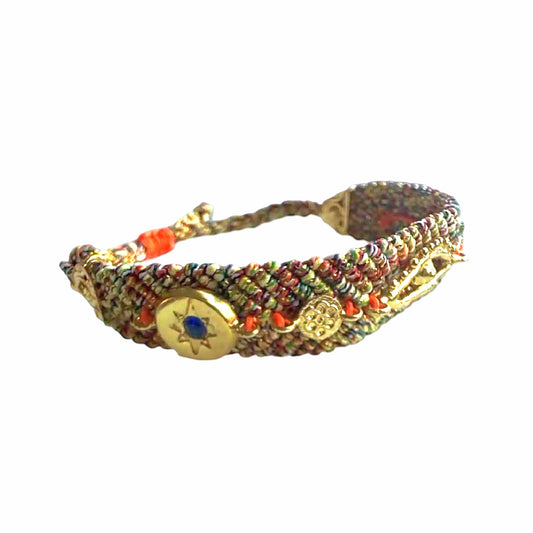 Handmade orange blue woven cord bracelet with gold-plated evil eye charm and zircon on a textured surface