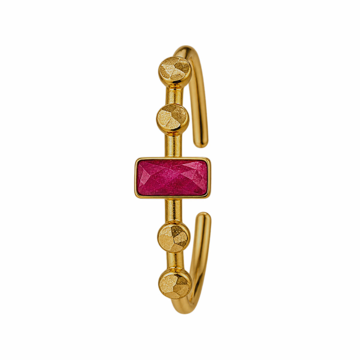 A gold-plated open cuff bangle bracelet featuring a central rectangular faceted ruby gemstone and four textured gold beads on each side of the stone, on a plain white background.