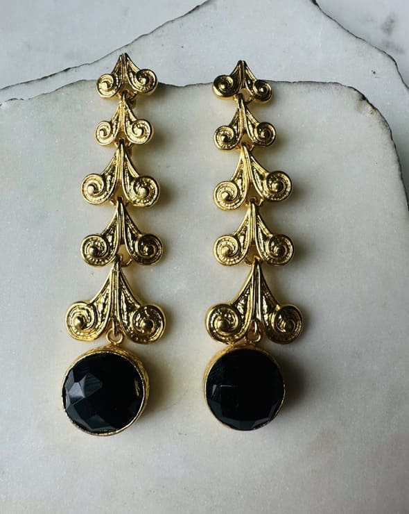 Artisanal sustainable Gold-plated long dangle earrings with round faceted black onyx stone on a marble surface