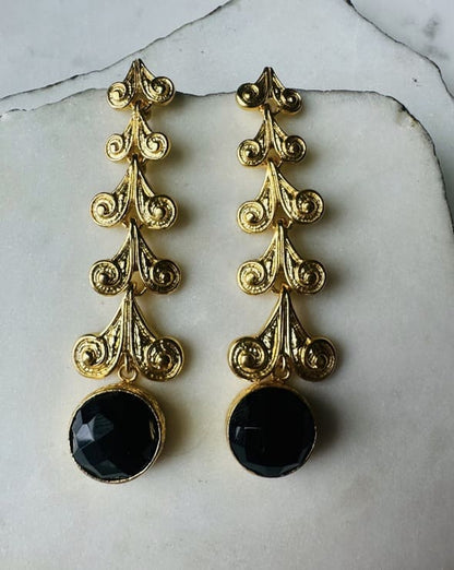 Artisanal sustainable Gold-plated long dangle earrings with round faceted black onyx stone on a marble surface