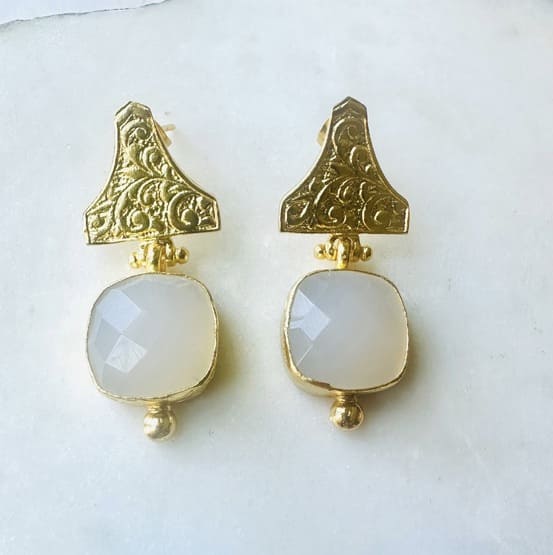 Handmade sustainable gold-plated faceted snow Quartz and Etruscan design drop earrings against white background 