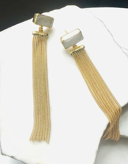 Handmade gold-plated sustainable snow Quartz earrings with long chain tassel on a white surface