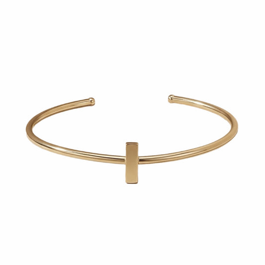 Dainty stackable Gold-plated bracelet with minimal bar on white surface 