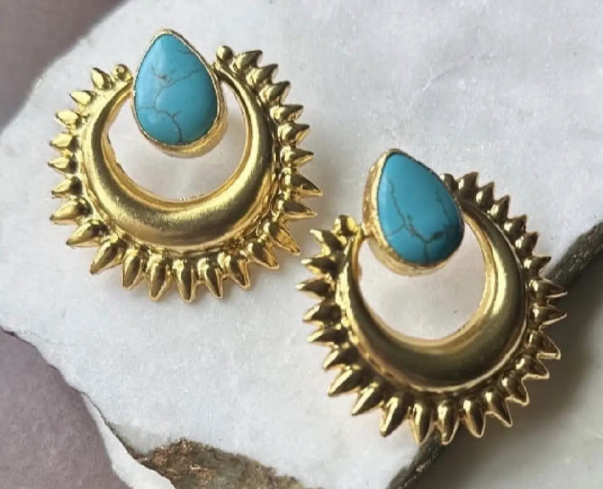 Artisanal sustainable Bold Gold-plated turquoise earrings with on a textured surface