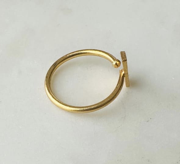 Sustainable artisanal Gold-plated anti-tarnish ring with rectangle bar on a light gray background facing the right 