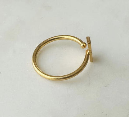 Sustainable artisanal Gold-plated anti-tarnish ring with rectangle bar on a light gray background facing the right 