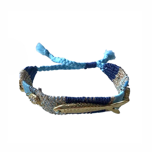Turquoise, Blue and gold woven bracelet with gold plated fish charms, crystals, and beach resort charms on a white surface