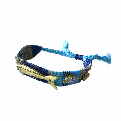 Turquoise, Blue and gold woven cord bracelet with gold plated fish charms, crystals, and beach resort charms on white 