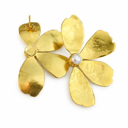 A pair of gold flower-shaped earrings with textured petals and a central white pearl, shown on a plain white background.