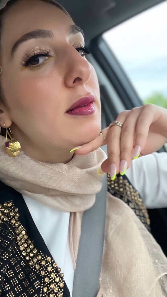 Muslim matchmaker Yasmin Elhady wearing gold-plated handmade ruby statement earrings  sitting in car