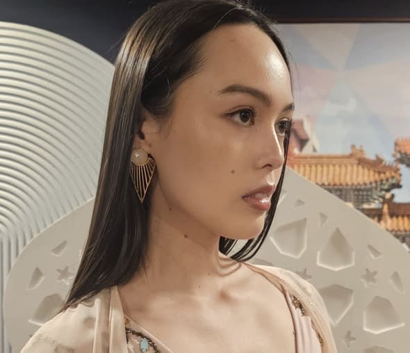 Model wearing artisanal gold-plates rose quartz earrings