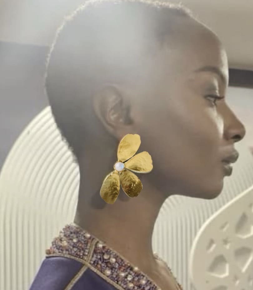 African American model’s side profile wearing artisanal bold gold-plated contemporary flower pearl earrings 
