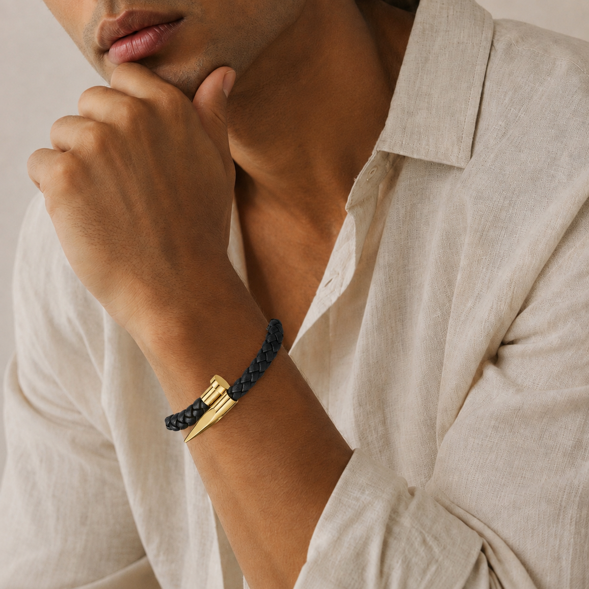 Man in banana republic beige linen button up collared shirt in natural light wearing a black woven gold nail design bracelet