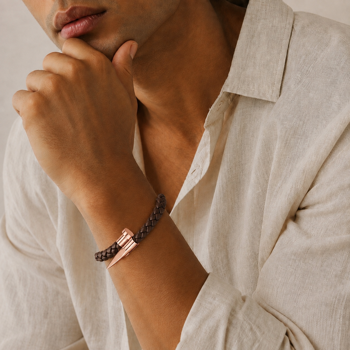Man in banana republic beige linen button up collared shirt in natural light wearing a brown woven rose gold nail design bracelet