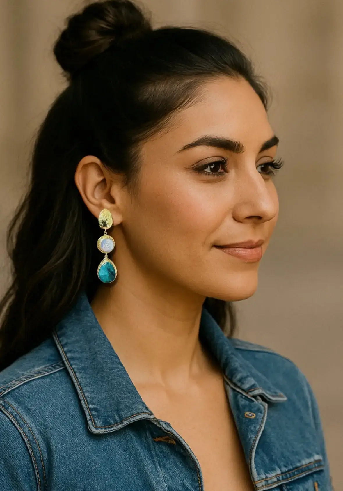 Model in Jean top wearing handmade gold-plated emerald and flat pearl dangle earrings 