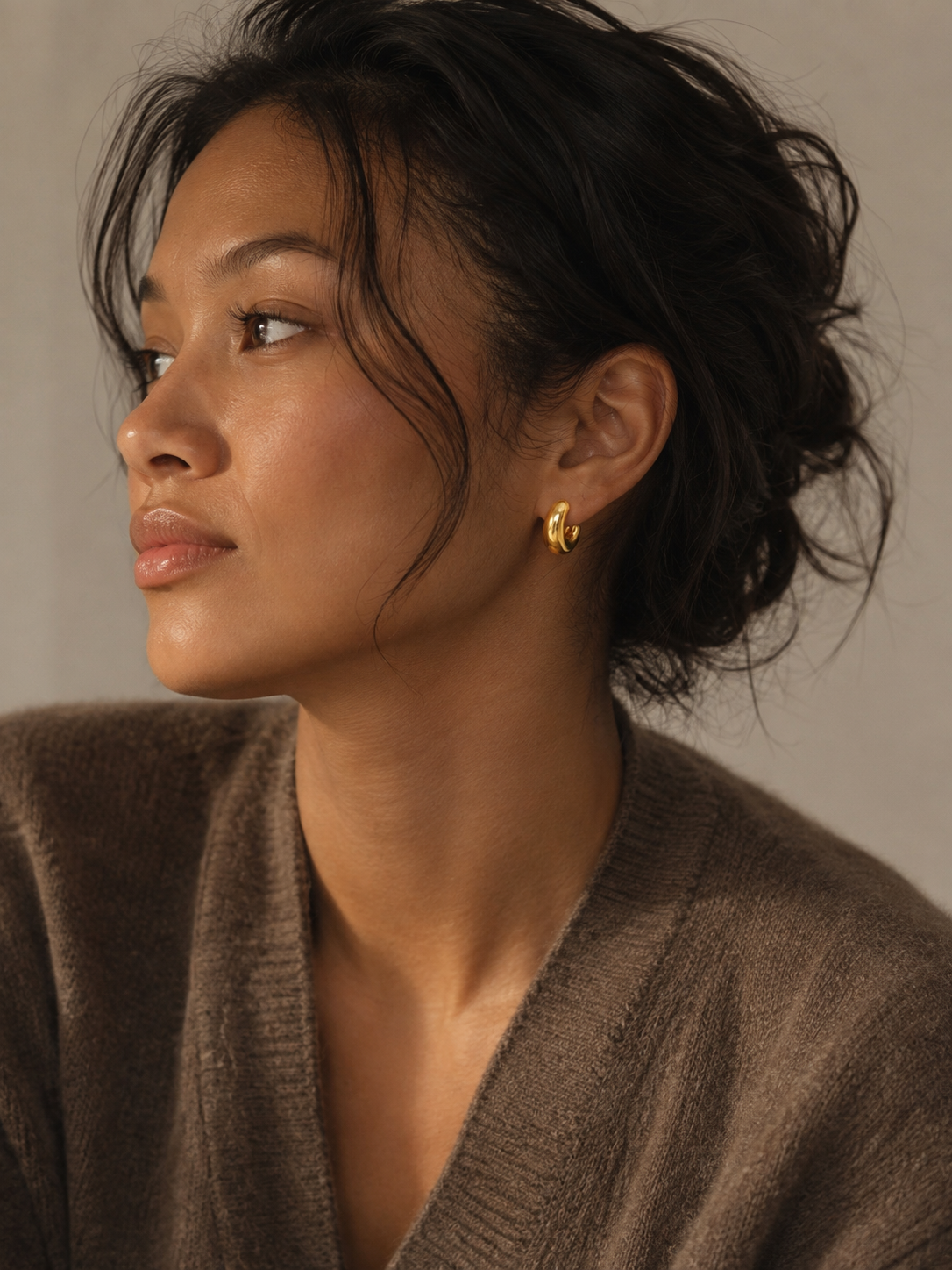 Model wearing brown oversized sweater and handmade gold plated Huggies