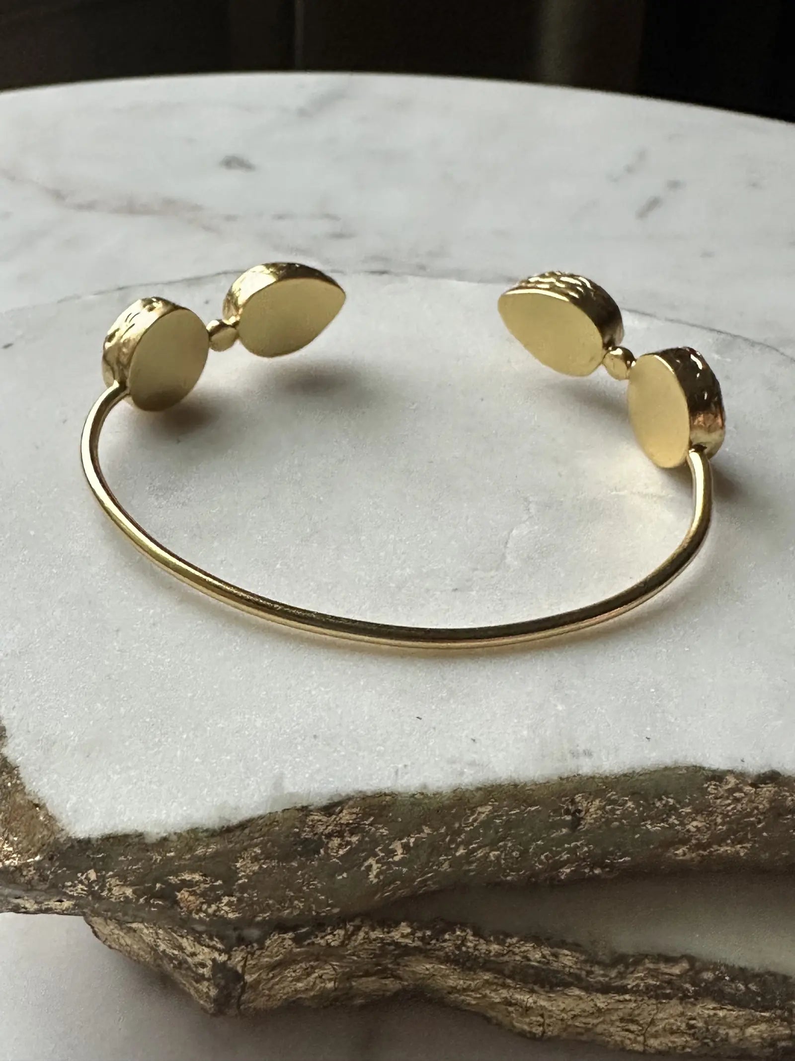 Small batch Gold-plated gemstone bracelet on a marble surface 