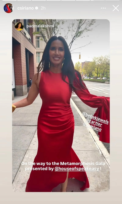 Padma Lakshmi in NYC wearing red satin dress by Siriano and gold long dangle earrings by Bebek Jewels