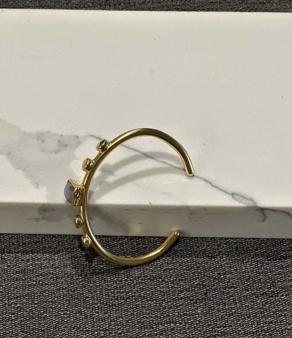 Side angle of artisanal eco-friendly Gold-plated labradorit bracelet on a marble surface
