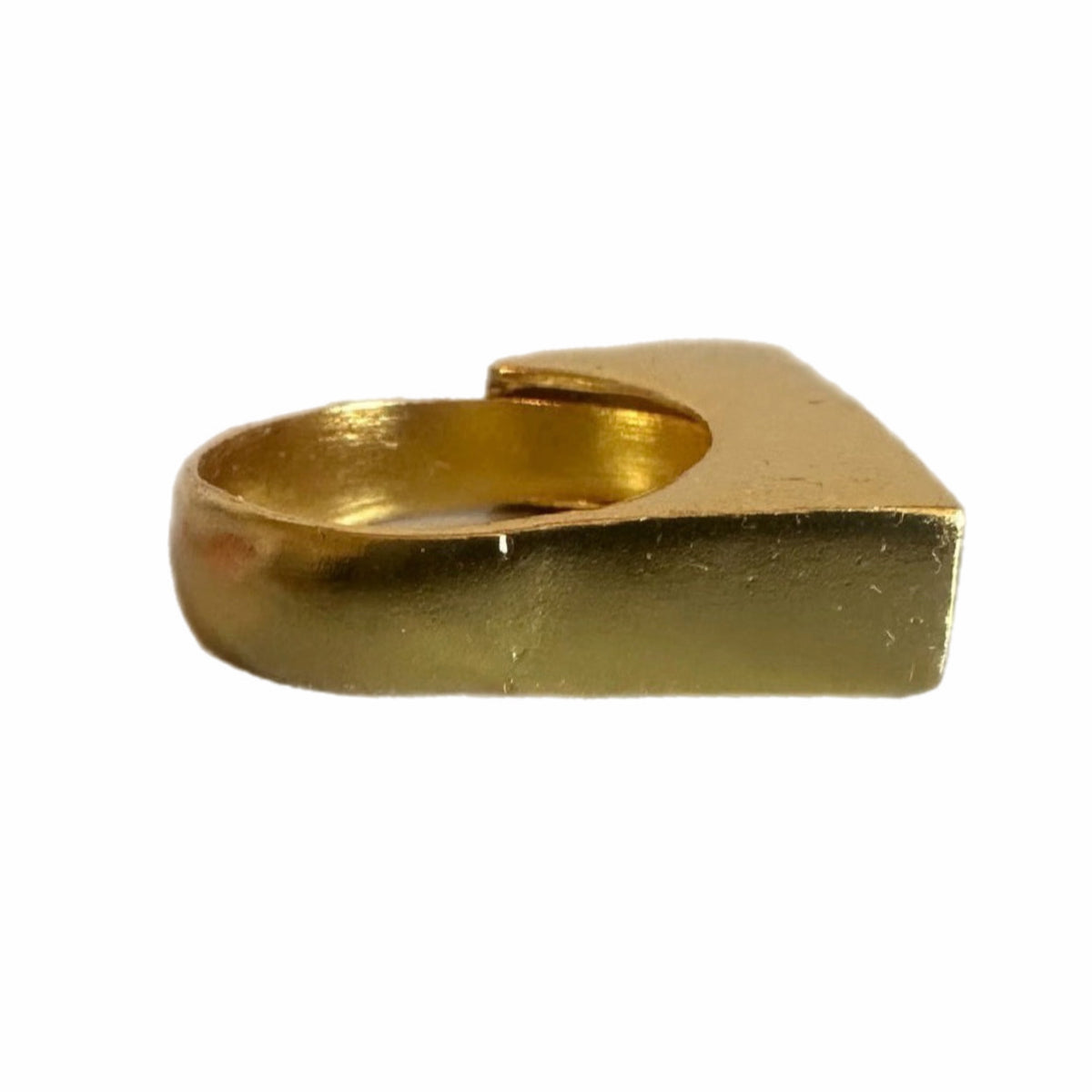 Side view of A gold-plated bar ring with Arabic calligraphy engraved on it, displayed on a white surface.