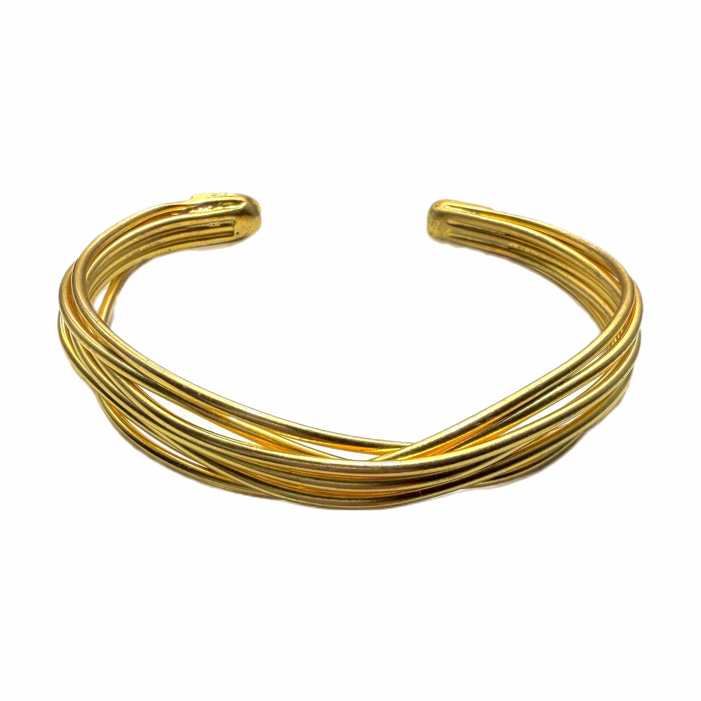 Gold-plated wire cuff bracelet on a wrist against a white background