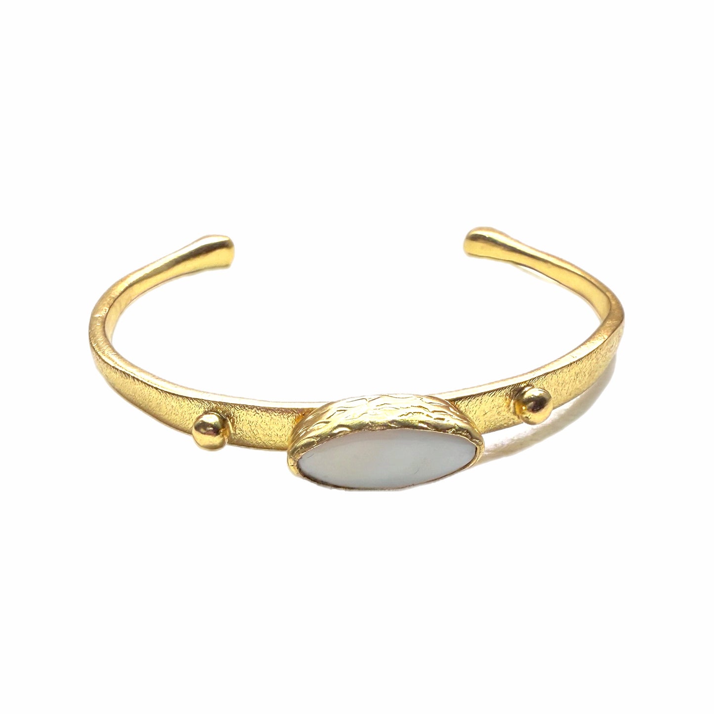 Gold-plated dainty bracelet with mother of pearl center laying on a white background 