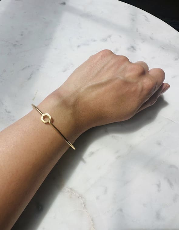 Dainty Gold-plated bracelet on a wrist against a marble background