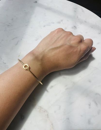 Dainty Gold-plated bracelet on a wrist against a marble background
