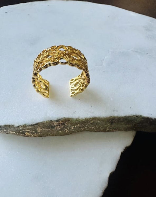 Gold-plated lace adjustable band on white surface