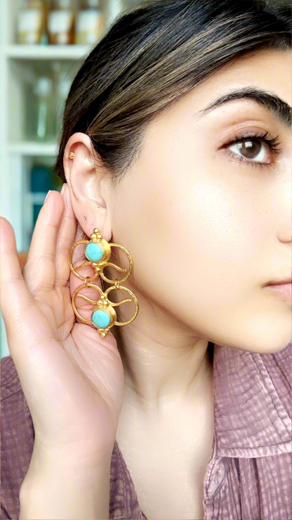 Close up of woman wearing bold artisanal gold-plated geometric turquoise earrings 