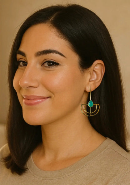 Woman wearing a stylish gold-plated contemporary aqua chalcedony earring against a neutral background