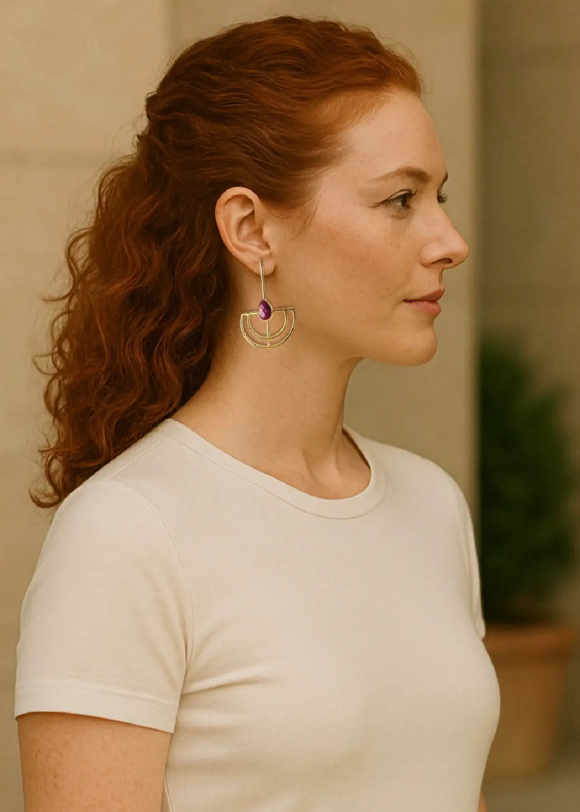 Woman wearing a white shirt and Bebek ruby gold-plated statement earrings