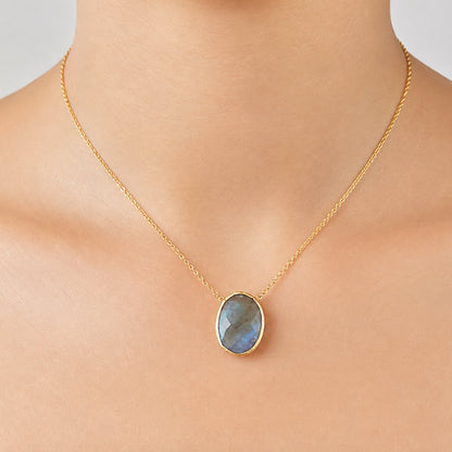 Zoomed in image of minimal gold chain faceted labradorite pendant necklace on models neck