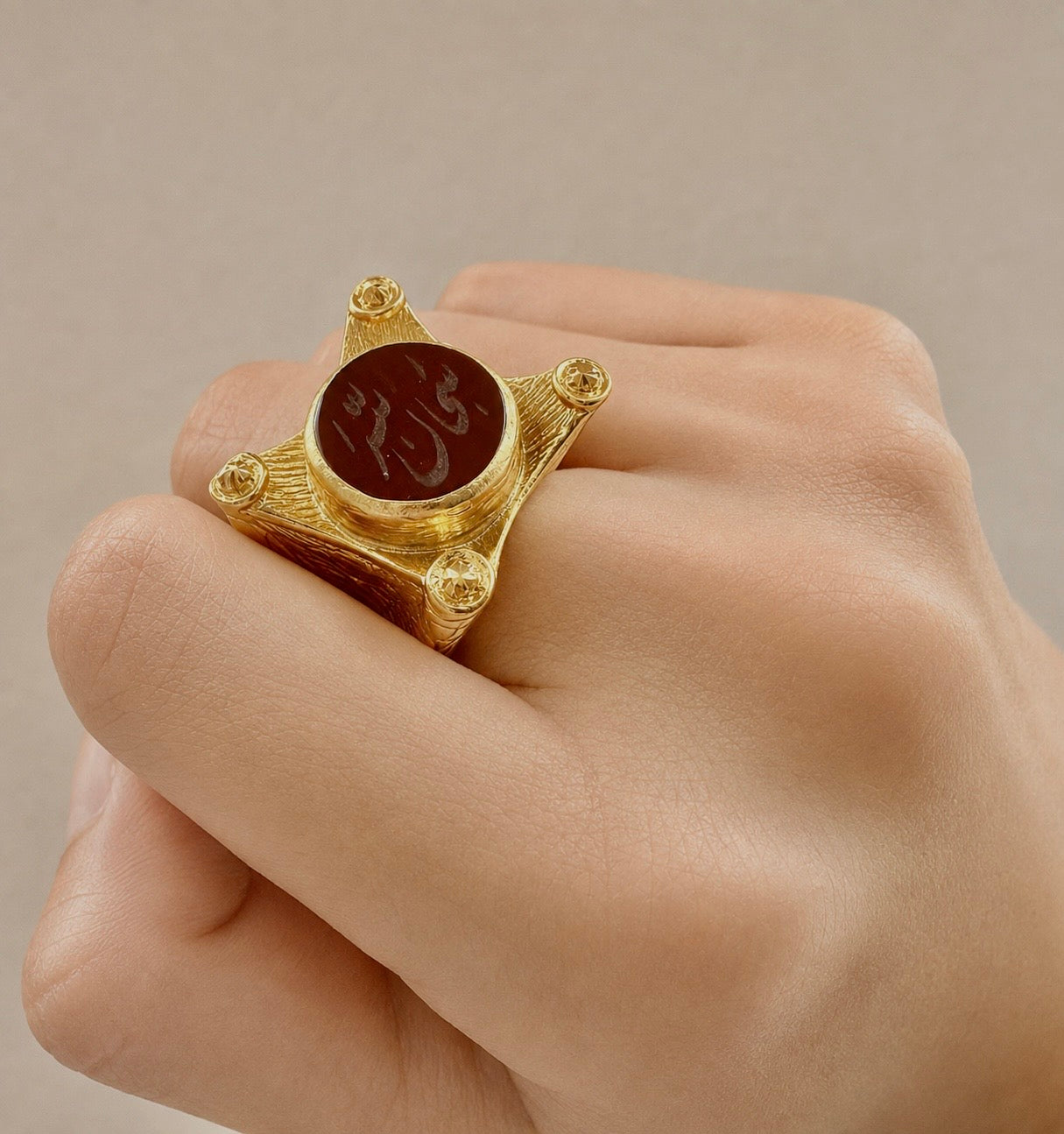 Zoomed view of A gold-plated ring with Arabic calligraphy 'SubhanAllah' written in the center using semi-precious gemstone agate.