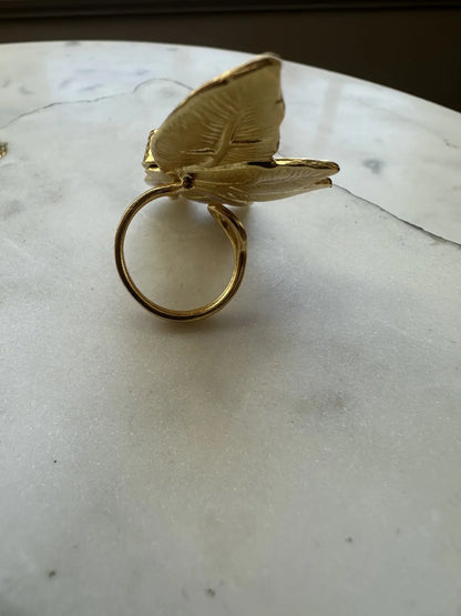 Back of Gold flower ring on a marble surface