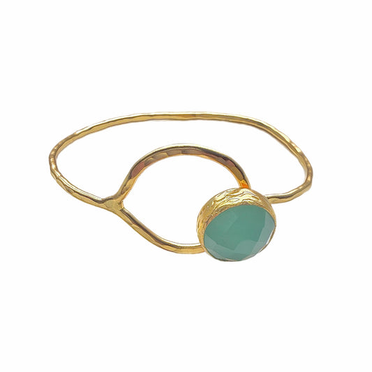 Artisanal gold-plated bracelet with round aqua chalcedony gemstone placed on white backdrop