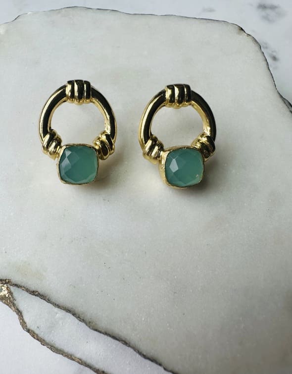 Handcrafted sustainable Gold-plated Aqua Chalcedony doorknocker stud earrings on a marble slabs